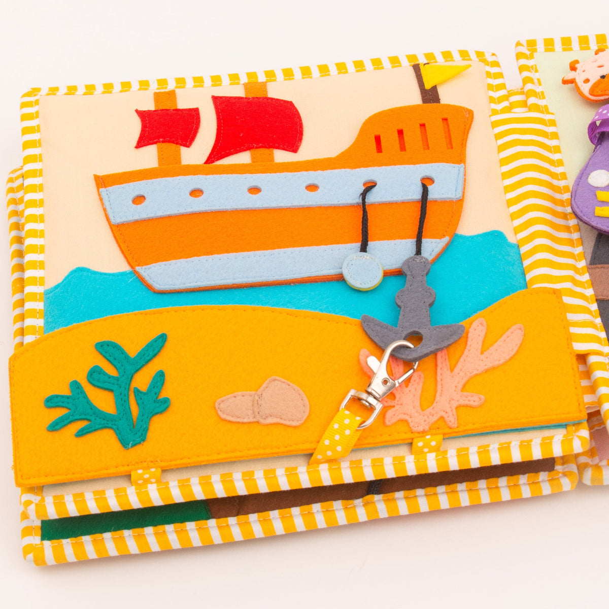 Page maritime du Quiet Book Globetrotter Jolly Designs : bateau rouge et blanc, poisson, coraux et attache de manipulation.