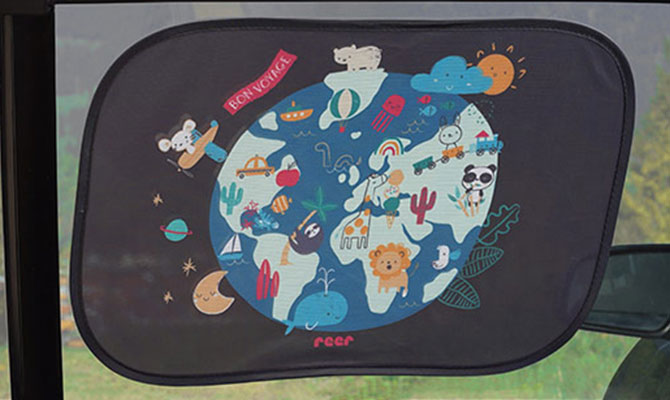 Gros plan du pare-soleil reer TravelKid Sun 86112 à motif carte du monde, monté sur une vitre de voiture.