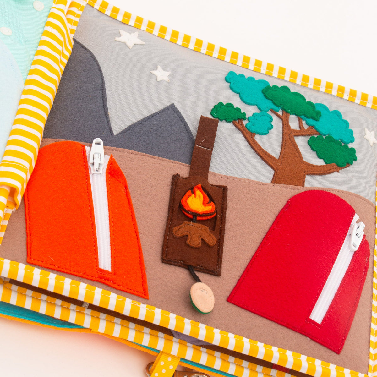 Page camping du Quiet Book Globetrotter Jolly Designs : tente rouge à fermeture éclair, feu de camp et montagne en feutrine.